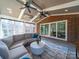 Sunroom featuring a brick accent wall, ceiling fans, and cozy seating with exterior view at 4127 Stacy Blvd, Charlotte, NC 28209