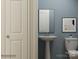 Modern half bathroom with a pedestal sink, framed mirror, and contemporary blue wall color at 4155 Skyboat Cir, Fort Mill, SC 29715