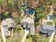 Stunning aerial view of a luxurious home with an in-ground pool, hot tub, playground, and lush landscaping at 4536 Rustling Woods Dr, Denver, NC 28037