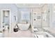 Modern bathroom features a soaking tub, elegant window, and marble shower at 4536 Rustling Woods Dr, Denver, NC 28037
