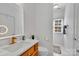 Modern bathroom featuring wood cabinets, a large mirror, and white walls at 4536 Rustling Woods Dr, Denver, NC 28037