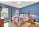 Cozy bedroom with blue walls, a ceiling fan, and a four-poster bed with a patterned rug at 4536 Rustling Woods Dr, Denver, NC 28037