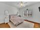 Bedroom includes a bed with pink comforter, rug, end tables, lamps, and a window at 4536 Rustling Woods Dr, Denver, NC 28037