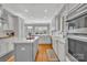 Well-lit kitchen features white cabinets, an island, stainless steel oven, and hardwood floors at 4536 Rustling Woods Dr, Denver, NC 28037