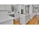 Bright kitchen features white cabinets, an island, stainless steel appliances, and hardwood floors at 4536 Rustling Woods Dr, Denver, NC 28037