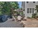 Inviting outdoor dining area with a stone patio, comfortable seating, a grill, and beautiful landscaping at 4536 Rustling Woods Dr, Denver, NC 28037