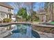Inviting pool and spa with stone accents, lounge chairs, and lush landscaping at 4536 Rustling Woods Dr, Denver, NC 28037