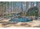 Private in-ground pool with stone waterfalls, a diving board, brick patio, and a charming pool house at 4536 Rustling Woods Dr, Denver, NC 28037