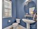 Stylish powder room featuring a round mirror, pedestal sink, and blue walls at 4536 Rustling Woods Dr, Denver, NC 28037