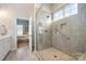 Modern glass enclosed shower with gray tile, grab bar, and a window for natural light at 456 Lucky Dr, Concord, NC 28027