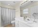 Bright bathroom features a vanity with a sink, window, and a shower with a curtain at 6635 Vlosi Dr, Charlotte, NC 28226