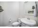 Simple powder room featuring a pedestal sink, toilet, framed mirror, and elegant decorative accents at 758 Waterscape Ct, Rock Hill, SC 29730