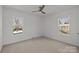 Bright bedroom featuring neutral walls, carpet flooring, two windows, and a ceiling fan at 9418 Stately Oak Ln, Mint Hill, NC 28227