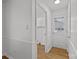 Bright hallway featuring neutral walls, wood-look flooring, and an entrance to a laundry area at 9418 Stately Oak Ln, Mint Hill, NC 28227