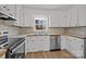 Close-up of the kitchen with a stainless steel dishwasher and tiled backsplash at 9418 Stately Oak Ln, Mint Hill, NC 28227