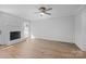 Bright living room featuring wood paneling, a brick fireplace, and modern ceiling fan at 9418 Stately Oak Ln, Mint Hill, NC 28227