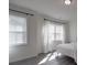 Light-filled bedroom with large windows, white curtains, and gray wood floors at 9786 Verdun Ct, Fort Mill, SC 29707