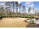 Large backyard featuring a patio with dining set, a fire pit, and lush landscaping at 1004 Whipcord Dr, Waxhaw, NC 28173