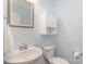 Powder room with a pedestal sink, mirrored medicine cabinet, and a toilet, all in a calming, pale blue color scheme at 1004 Whipcord Dr, Waxhaw, NC 28173