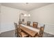 Elegant dining room showcasing a large wood table, chair set, and classic wainscoting, adjacent to an open kitchen at 1004 Whipcord Dr, Waxhaw, NC 28173