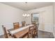 Formal dining room featuring wainscoting, wood table with 6 chairs, and natural light from the window at 1004 Whipcord Dr, Waxhaw, NC 28173