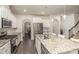 Modern white kitchen featuring granite countertops, stainless steel appliances, and a large island with pendant lighting at 1004 Whipcord Dr, Waxhaw, NC 28173