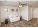 Cozy living room with wood floors, a white couch, and end tables, illuminated by a ceiling fan and natural light at 1004 Whipcord Dr, Waxhaw, NC 28173