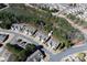 Aerial view of townhomes backing up to a pond surrounded by lush greenery and mature trees at 1005 Sweetleaf Dr, Fort Mill, SC 29707