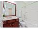 Bright bathroom featuring a cherry vanity, a soaking tub, and a large framed mirror at 1005 Sweetleaf Dr, Fort Mill, SC 29707