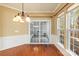 Bright dining room features hardwood floors, elegant wainscoting, chandelier, and sliding glass doors to the screened-in porch at 1005 Sweetleaf Dr, Fort Mill, SC 29707