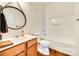 Bright bathroom featuring a shower-tub combo, modern fixtures, and stylish round mirror over the vanity sink at 10123 Barrands Ln, Charlotte, NC 28278