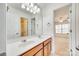 Bright bathroom featuring double sinks with wooden cabinets and a large mirror, plus shower and bedroom views at 10123 Barrands Ln, Charlotte, NC 28278