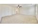 Large bedroom featuring neutral walls and carpeting, ceiling fan, and doorways to bathroom and closets at 10123 Barrands Ln, Charlotte, NC 28278