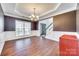 Formal dining room featuring hardwood floors, chandelier, wainscoting, and large window at 10123 Barrands Ln, Charlotte, NC 28278