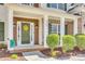 Inviting front porch with classic columns, a green door with wreath, and manicured shrubs at 10123 Barrands Ln, Charlotte, NC 28278