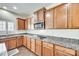 Functional kitchen design with granite countertops, wood cabinetry, and stainless steel microwave at 10123 Barrands Ln, Charlotte, NC 28278