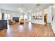 Open-concept living room with hardwood floors, fireplace, ceiling fan, and view of the kitchen at 10123 Barrands Ln, Charlotte, NC 28278