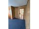 Bedroom with wood paneled walls, blue carpet, and interior door at 1027 Morningside Park Dr, Gastonia, NC 28054