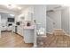 Modern kitchen with white cabinetry, stainless steel appliances, breakfast bar, and hardwood flooring, offering space for entertaining at 12207 Jessica Pl, Charlotte, NC 28269