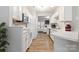 Modern kitchen with white cabinets, stainless steel appliances, bar seating, open concept, hardwood floors, and tile backsplash at 12207 Jessica Pl, Charlotte, NC 28269