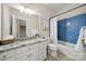 Bathroom with white cabinets, granite counters, blue tiled shower, and framed mirror at 1569 Benjamen Latrobe Cir, Fort Mill, SC 29708