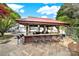 Outdoor cabana with a bar, seating, and views of the beautifully landscaped backyard and luxurious pool at 1569 Benjamen Latrobe Cir, Fort Mill, SC 29708