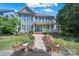 Charming two-story home with a welcoming front porch, blue shutters and professionally landscaped front yard at 1569 Benjamen Latrobe Cir, Fort Mill, SC 29708