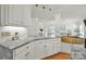 Stylish kitchen with marble countertops, white cabinets, designer hardware, and a farmhouse sink at 1569 Benjamen Latrobe Cir, Fort Mill, SC 29708