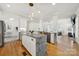 Open-concept kitchen with an oversized island, stainless steel appliances, and hardwood floors at 1569 Benjamen Latrobe Cir, Fort Mill, SC 29708