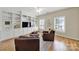 Living room featuring hardwood floors, a ceiling fan, a built-in cabinet, and two leather chairs at 1569 Benjamen Latrobe Cir, Fort Mill, SC 29708