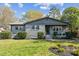 Charming single-story home with a well-maintained lawn and stone facade, set against a backdrop of mature trees at 1749 Archdale Dr, Charlotte, NC 28210