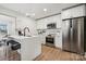 Bright, modern kitchen featuring a waterfall island, stainless steel appliances, and stylish white cabinetry at 1749 Archdale Dr, Charlotte, NC 28210