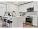 Modern kitchen with a quartz waterfall island, stainless steel appliances, and stylish white cabinetry at 1749 Archdale Dr, Charlotte, NC 28210