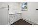 Well-lit laundry room features built-in cabinets and a window at 1749 Archdale Dr, Charlotte, NC 28210